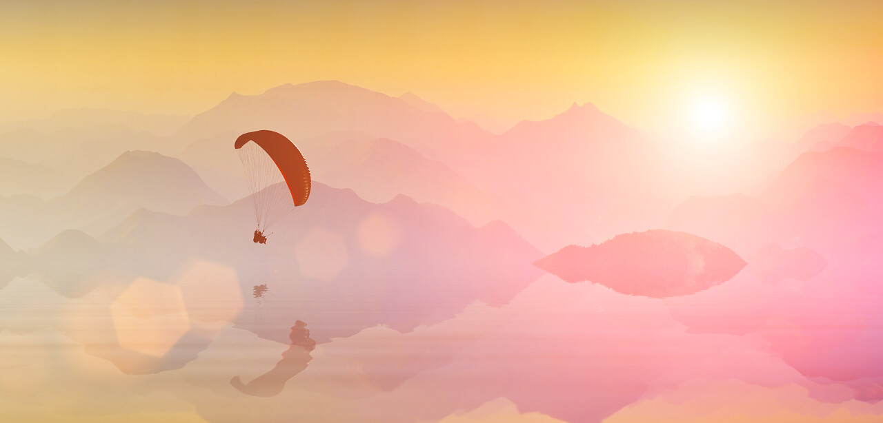 滑翔伞在山湖上映在水面上