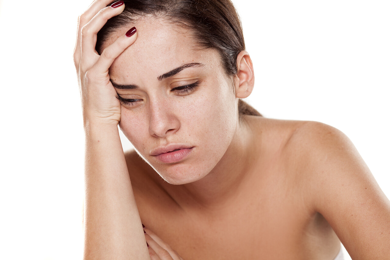 悲伤和失望的年轻女子在白色背景靠在她的手