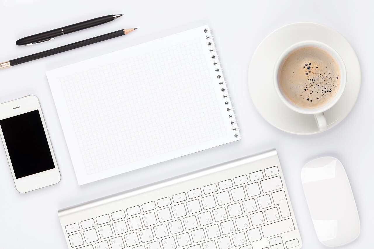 办公室桌子上放着计算机日用品和咖啡