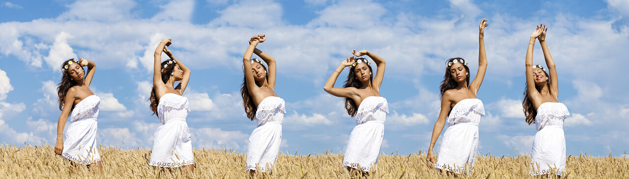 美丽性感的年轻女人在金色的麦田里舞蹈