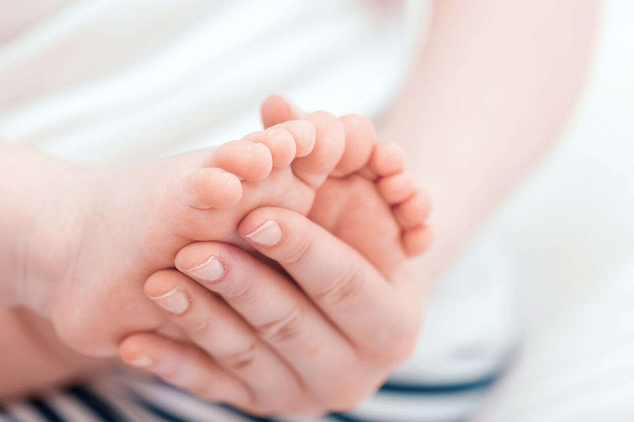 母亲小心翼翼地抱着婴儿的小脚