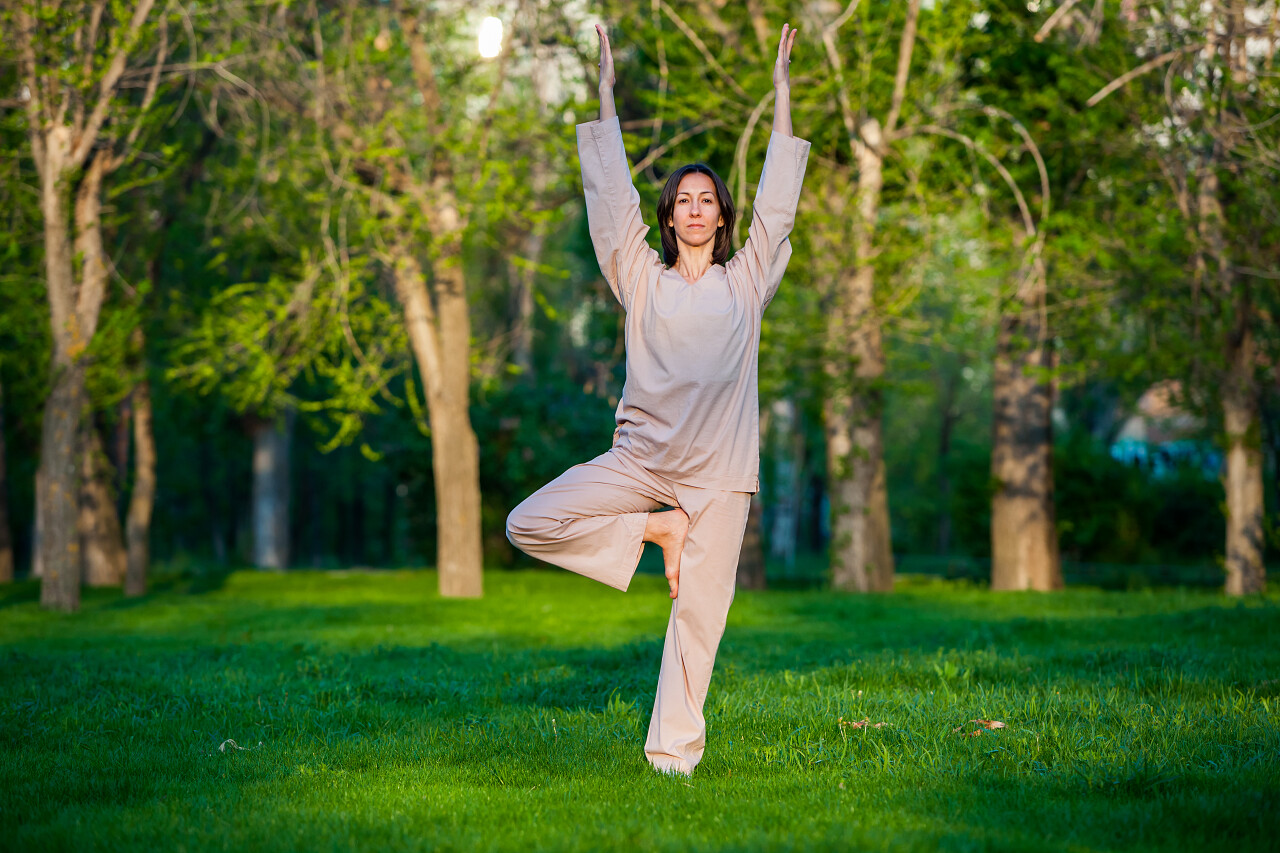 公园附近的松树下做瑜伽的女人户外瑜伽