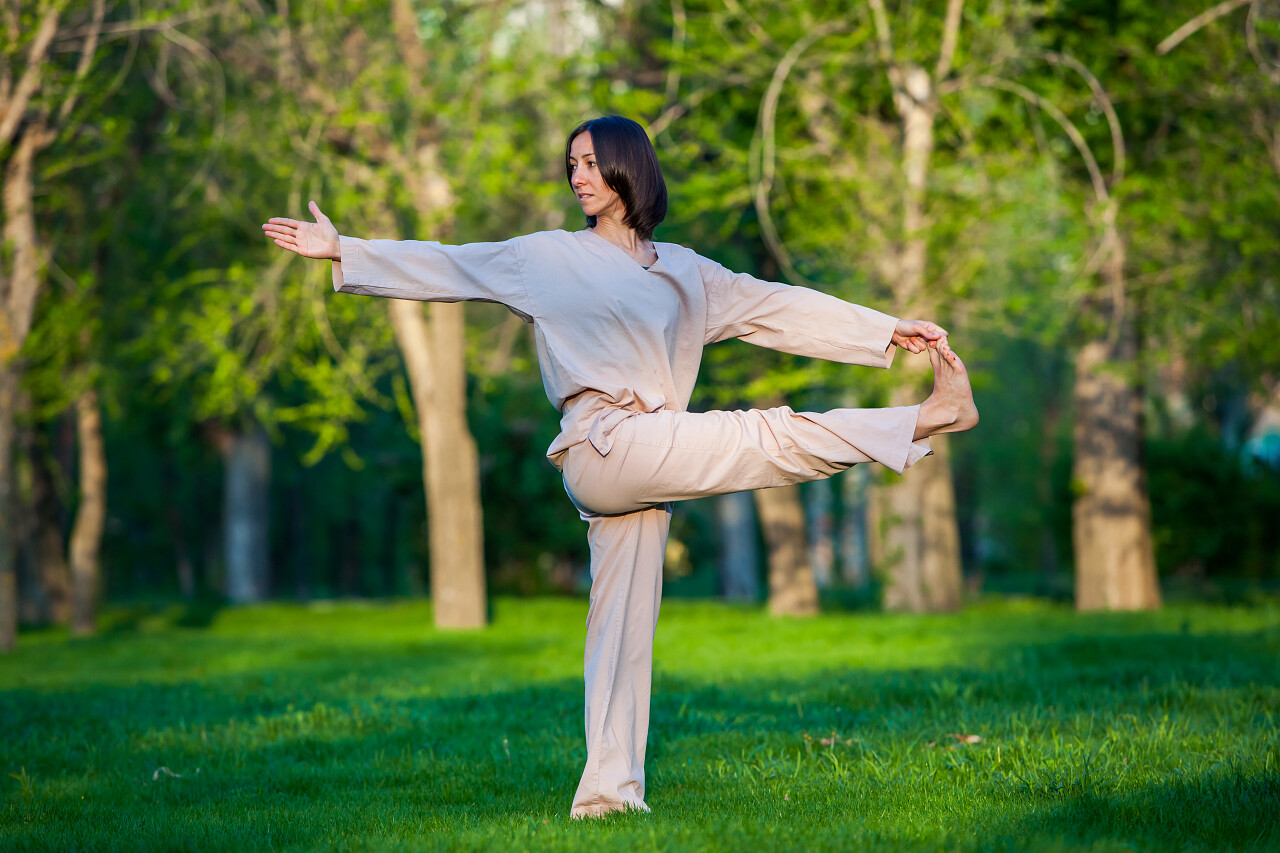 绿色草上练瑜伽的女人户外瑜伽