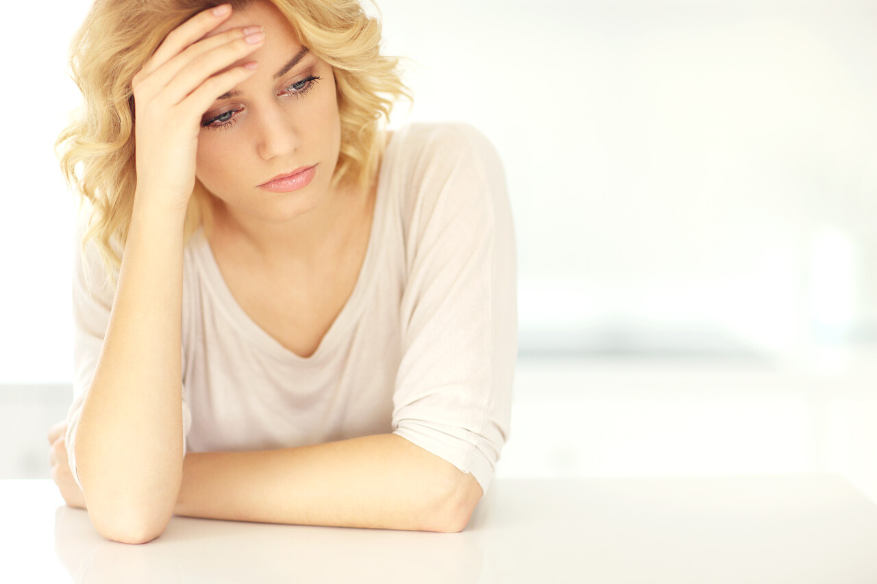 一张年轻患有抑郁症的妇女在家里头痛的后悔图片