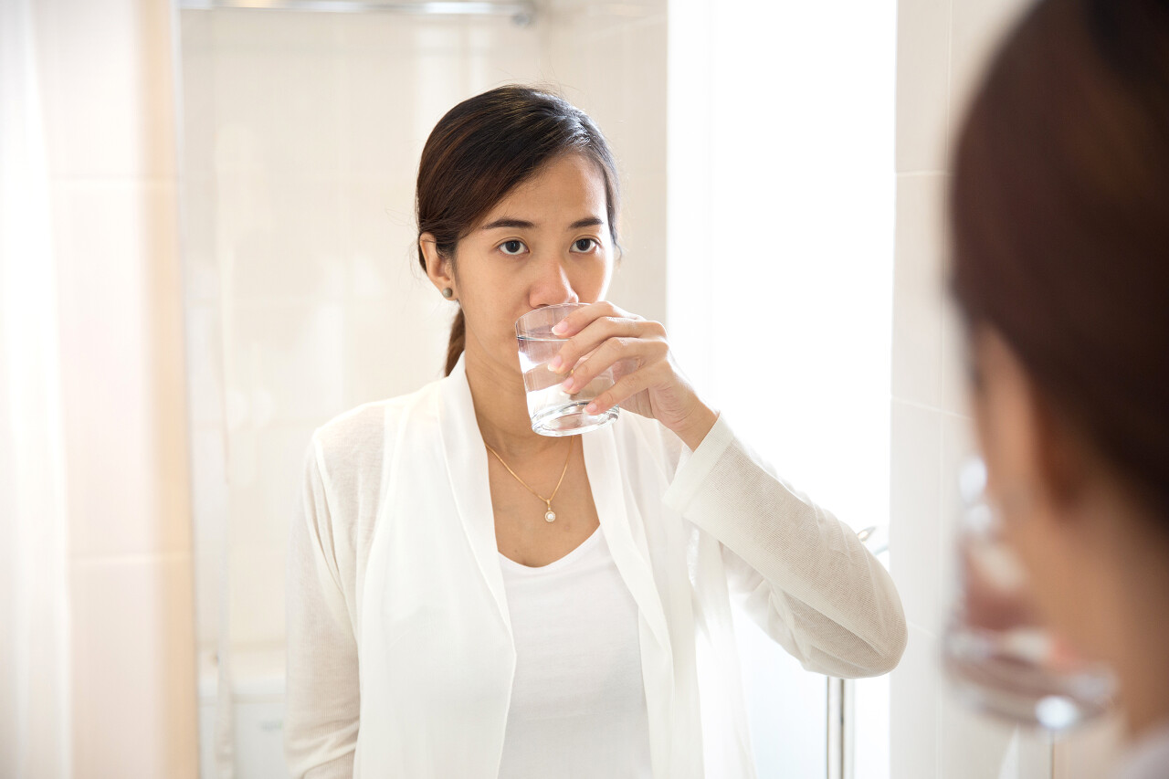 亚洲年轻女人含漱液后刷牙的肖像