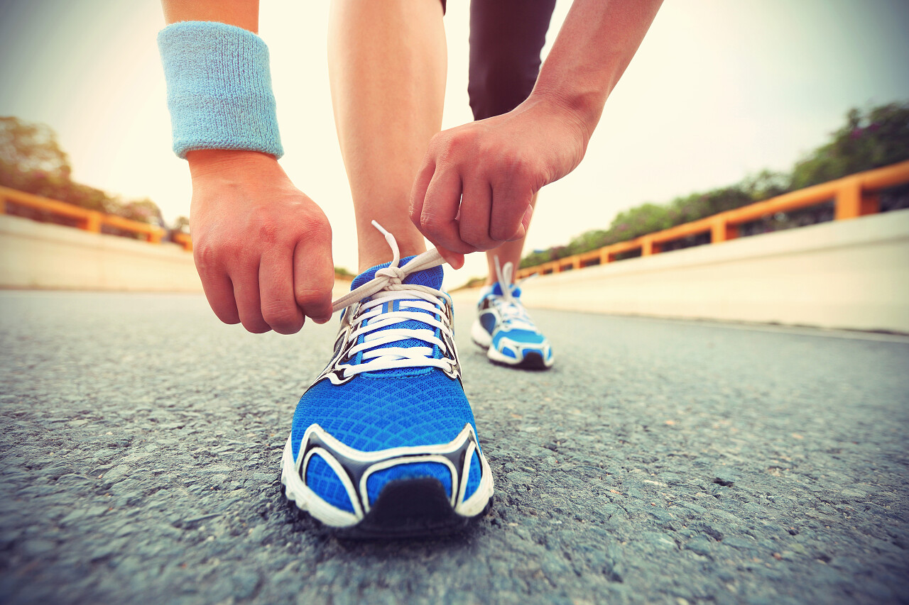 年轻女子赛跑者在城市道路上绑鞋带励志跑步 奔跑运动健身户外跑步