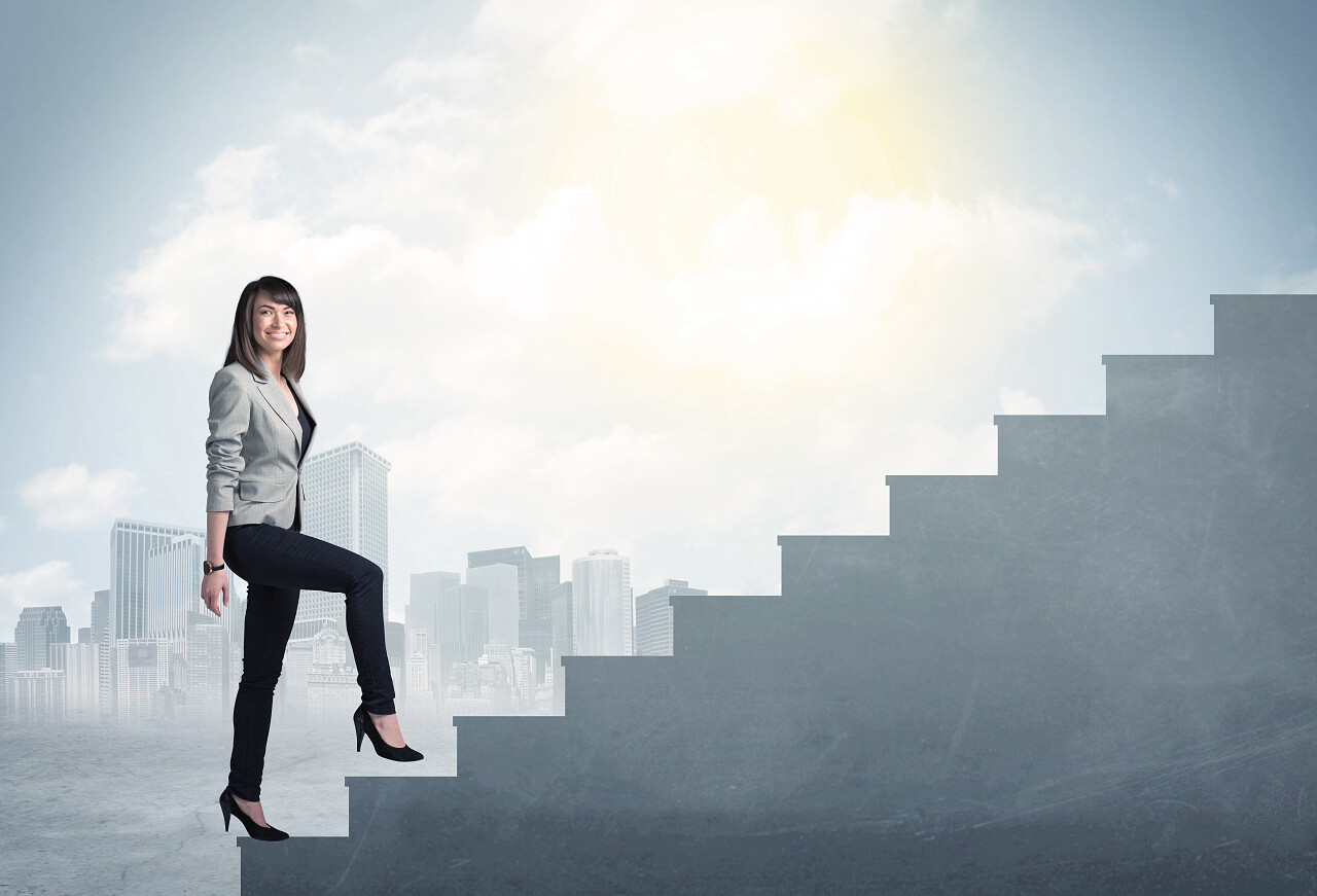 女商人在城市背景下攀爬土楼梯