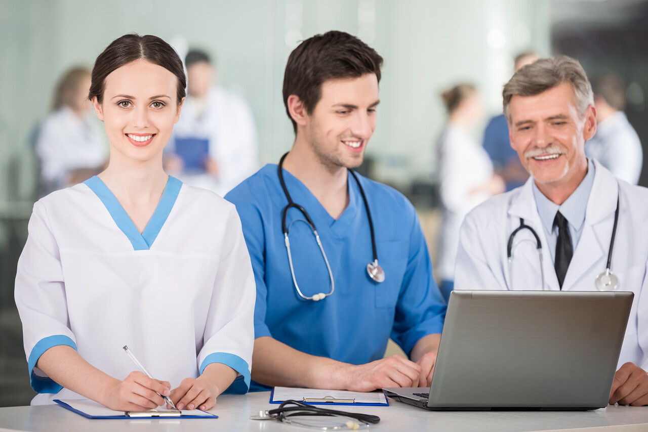 一组医生在医生办公室一起使用笔记本电脑