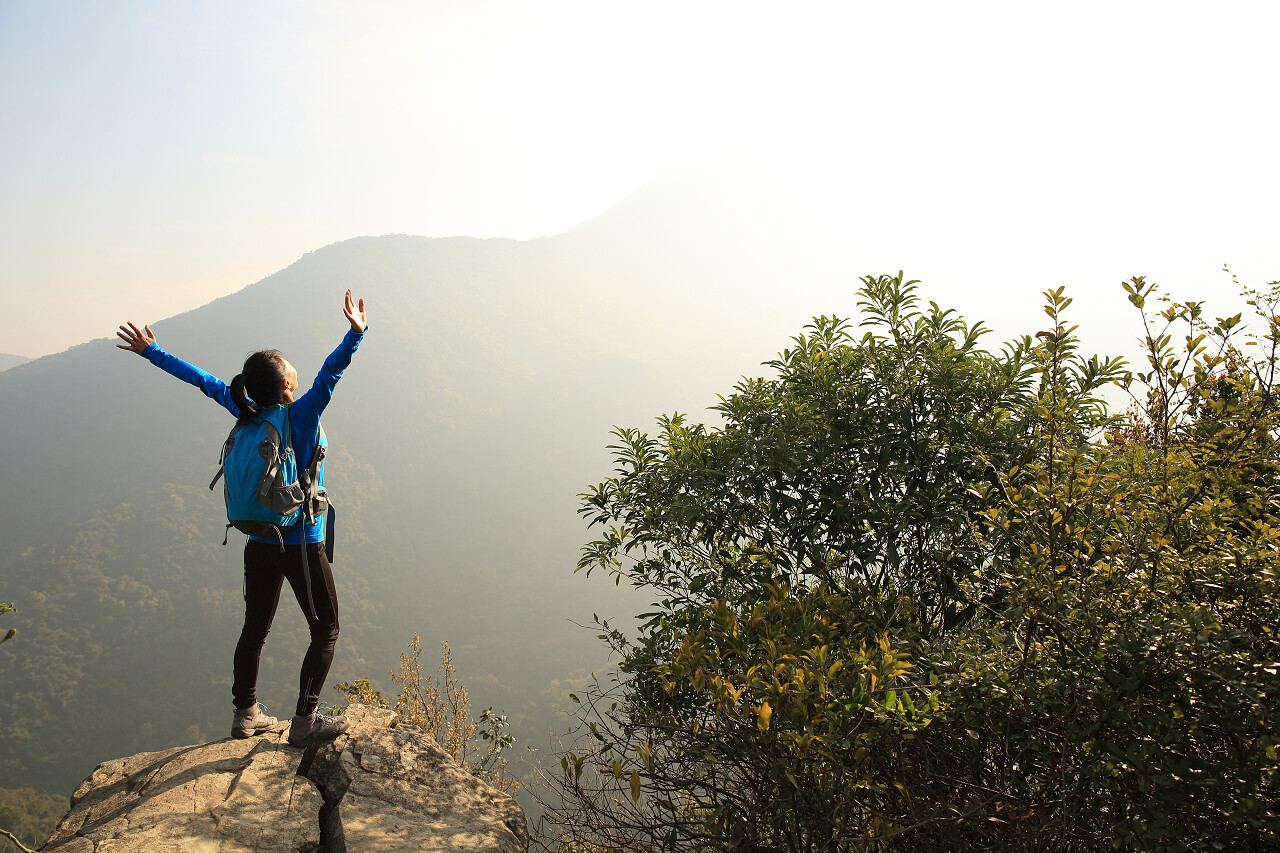 绿色登山者在山顶张开双臂欢呼的女人励志励志努力胜利坚持不懈挑战极限突破自我