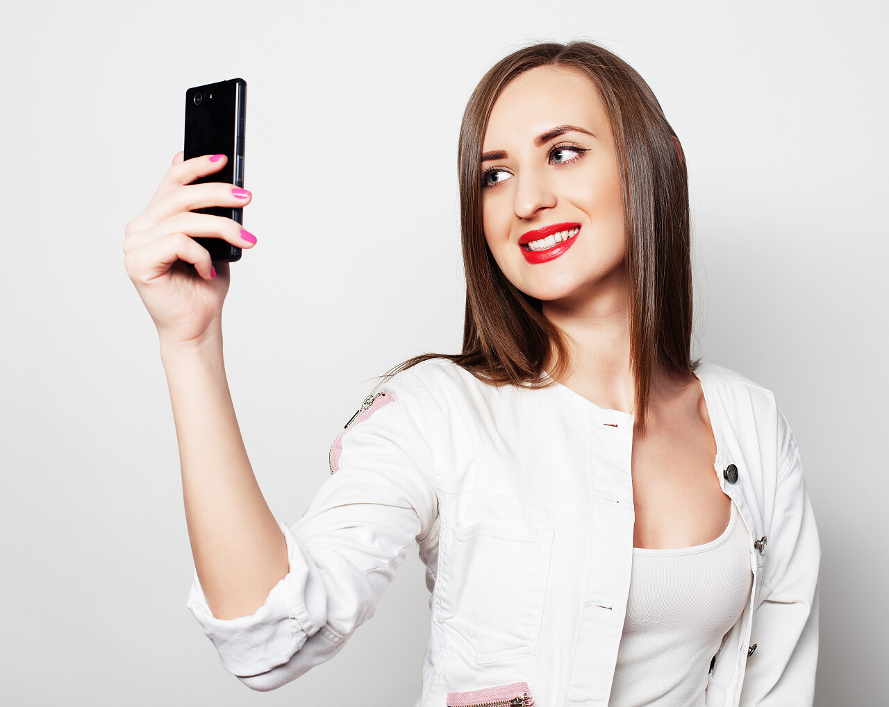 白色背景年轻漂亮的女人在使用手机