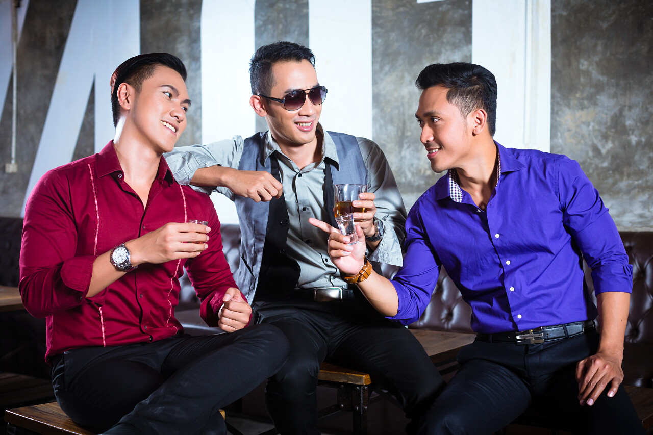 灰色背景夜总会亚洲男性朋友喝酒