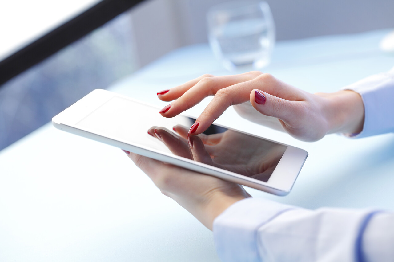 白色背景上女商人拿着平板电脑在工作