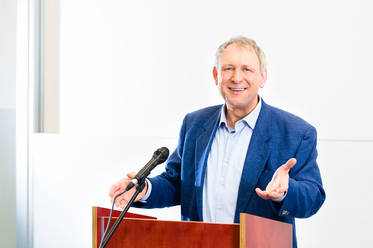 白色教室大学教授讲学并站在课桌前传授知识