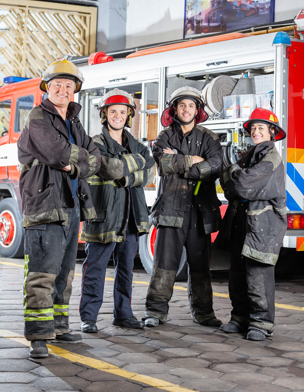 消防局里自信消防队员站在消防车前面