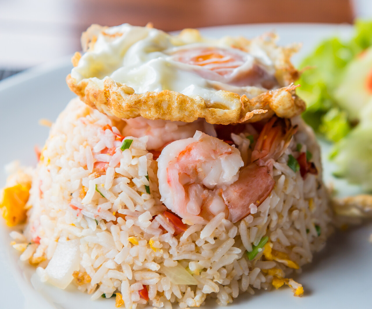 白色盘子里蔬菜和鸡蛋的虾炒饭