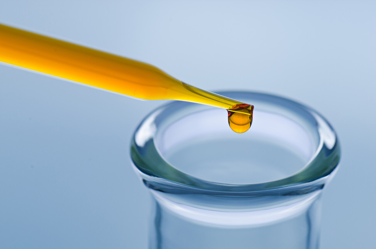 灰色背景科学实验室里滴管放在玻璃瓶上