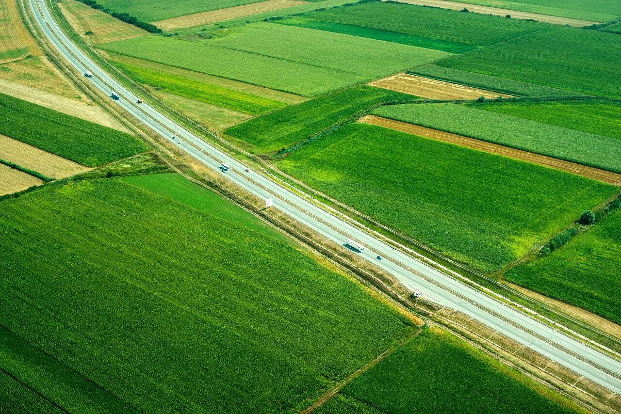 夏天俯拍公路移动和绿色田野希望的田野