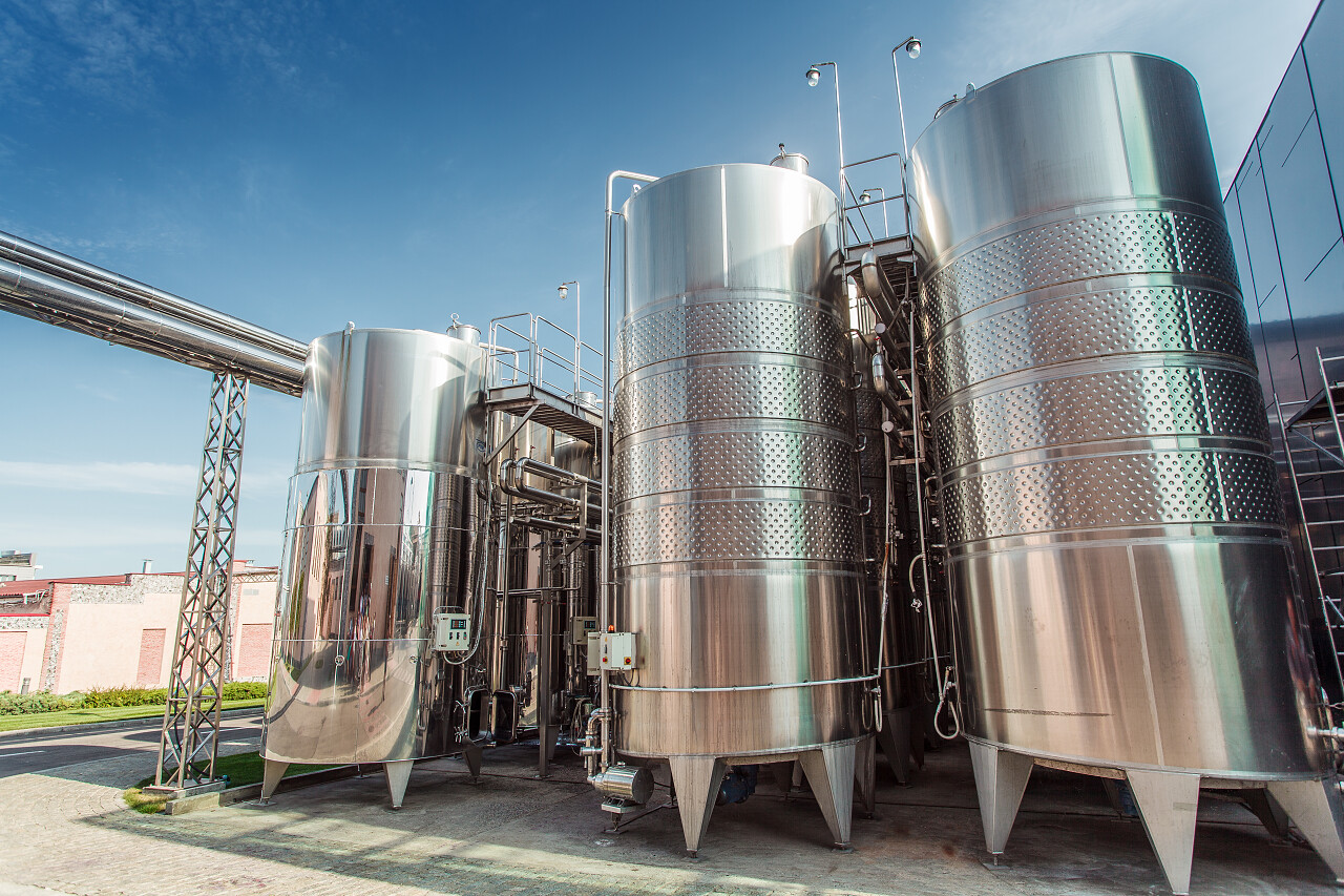 蓝色天空下现代酿酒发酵罐不锈钢麦汁