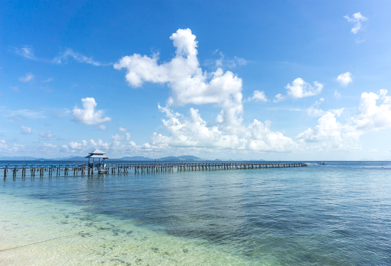 蓝色天空下美丽的海滩和码头