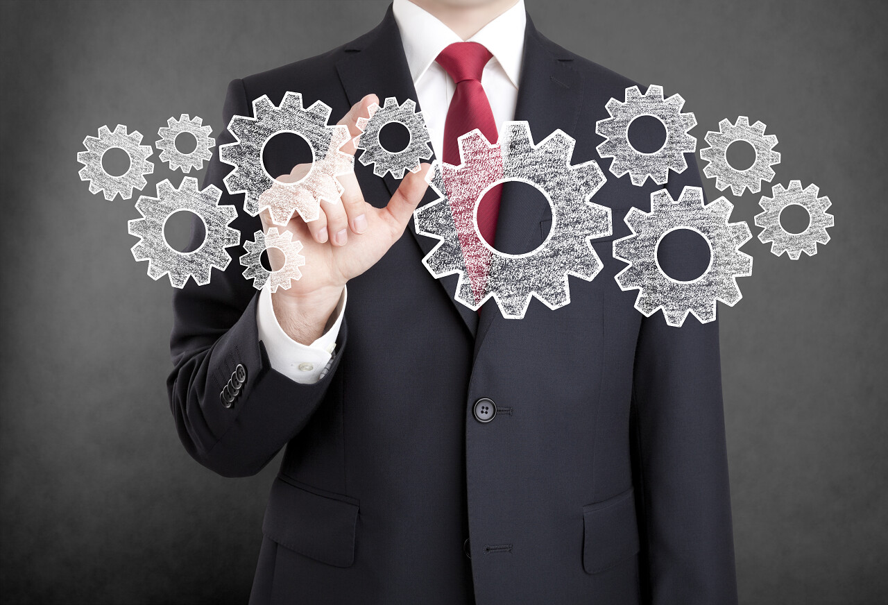 商人手指拿着齿轮和很多齿轮