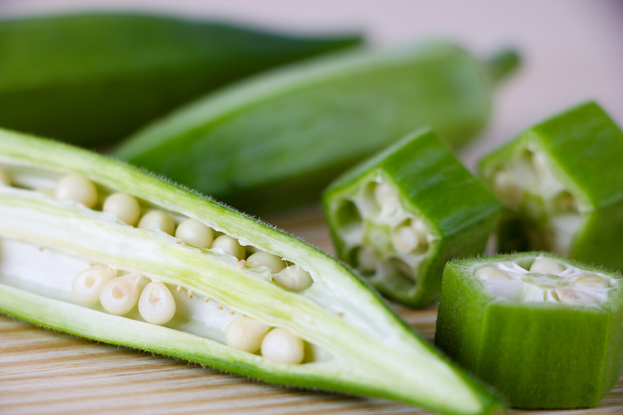 木质桌子上有绿色被切开的秋葵