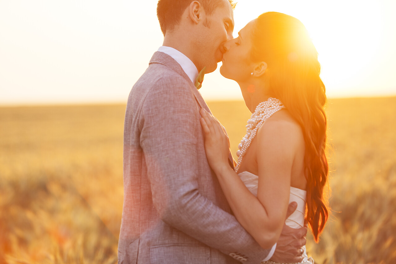 日落下新婚夫妇在麦田上接吻幸福婚姻情侣幸福情侣幸福的人