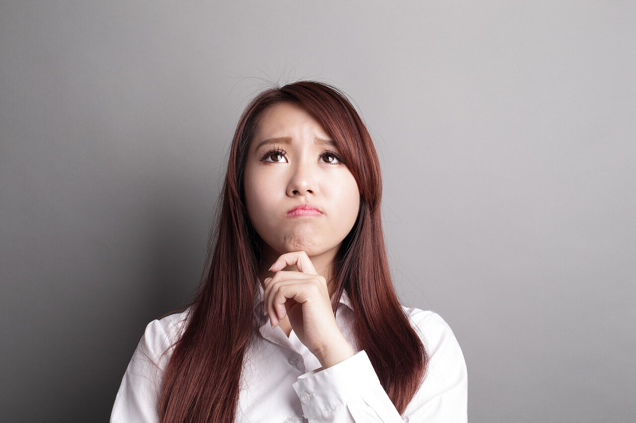 在灰色背景下思考的女人思维