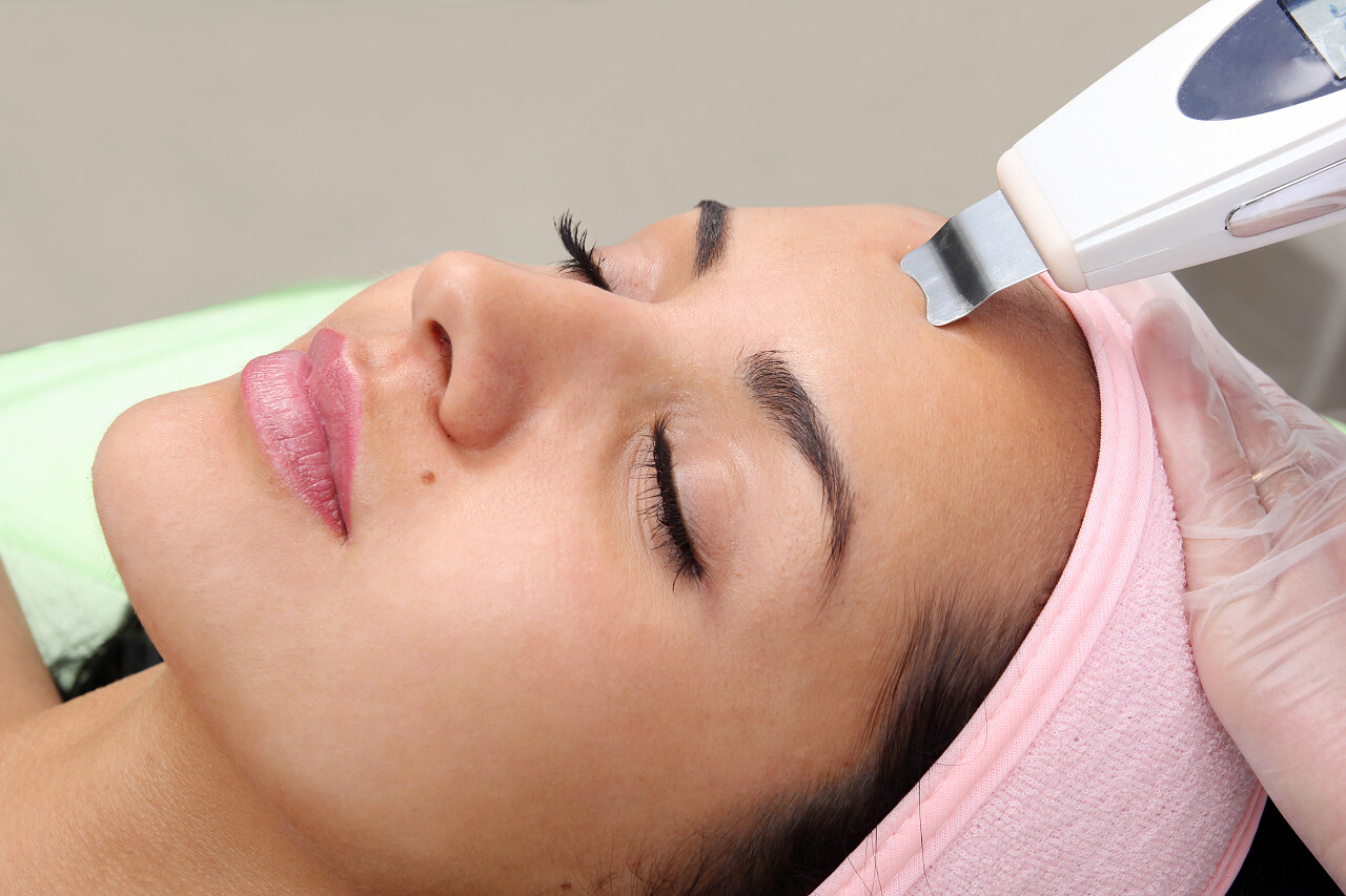 女人在美容院接受专业的超声波设备清洗