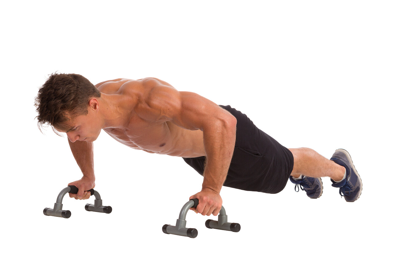 白色的背景下肌肉男做健身