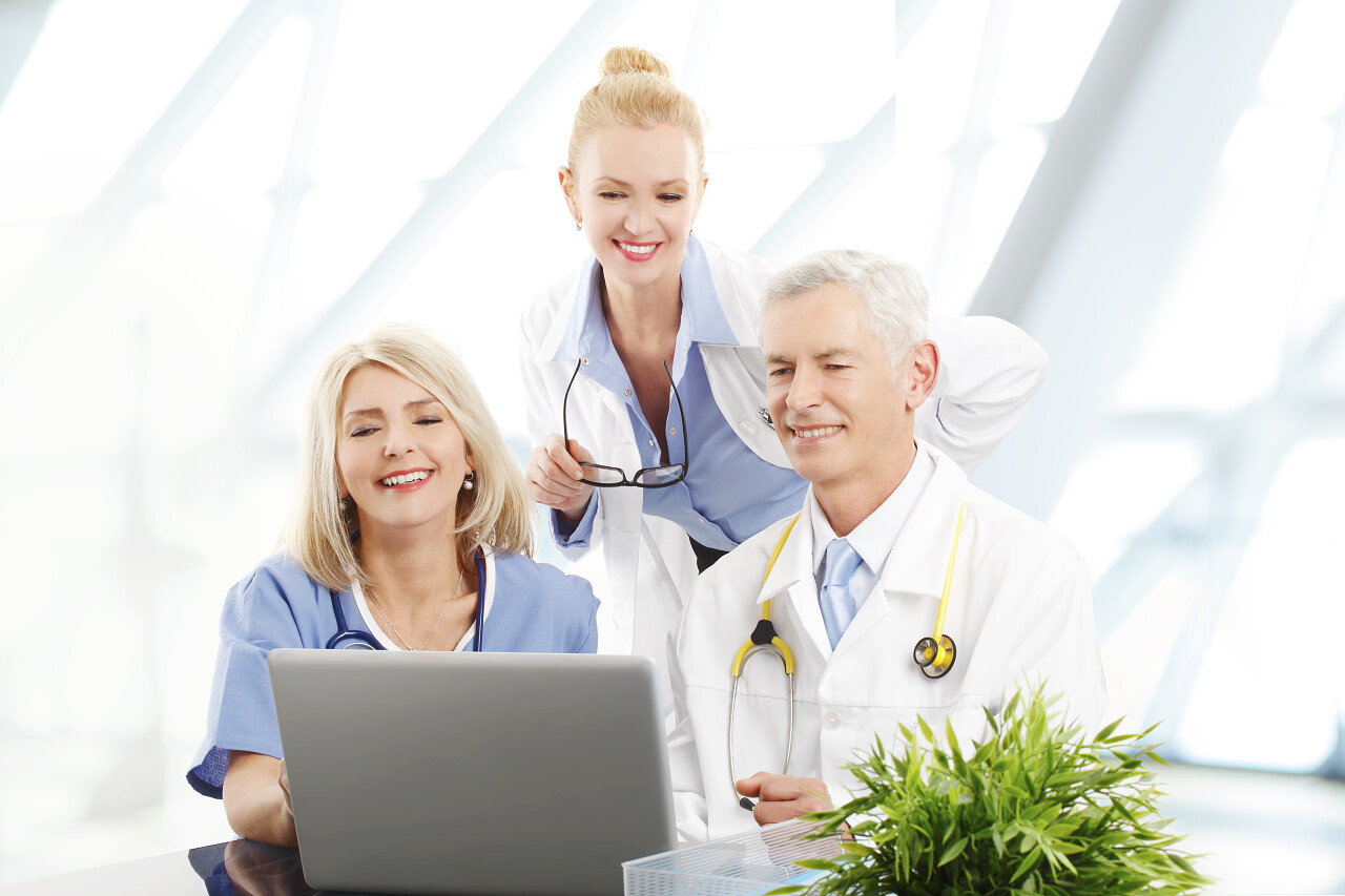 带着笔记本电脑两女一男医生在进行团队医疗工作