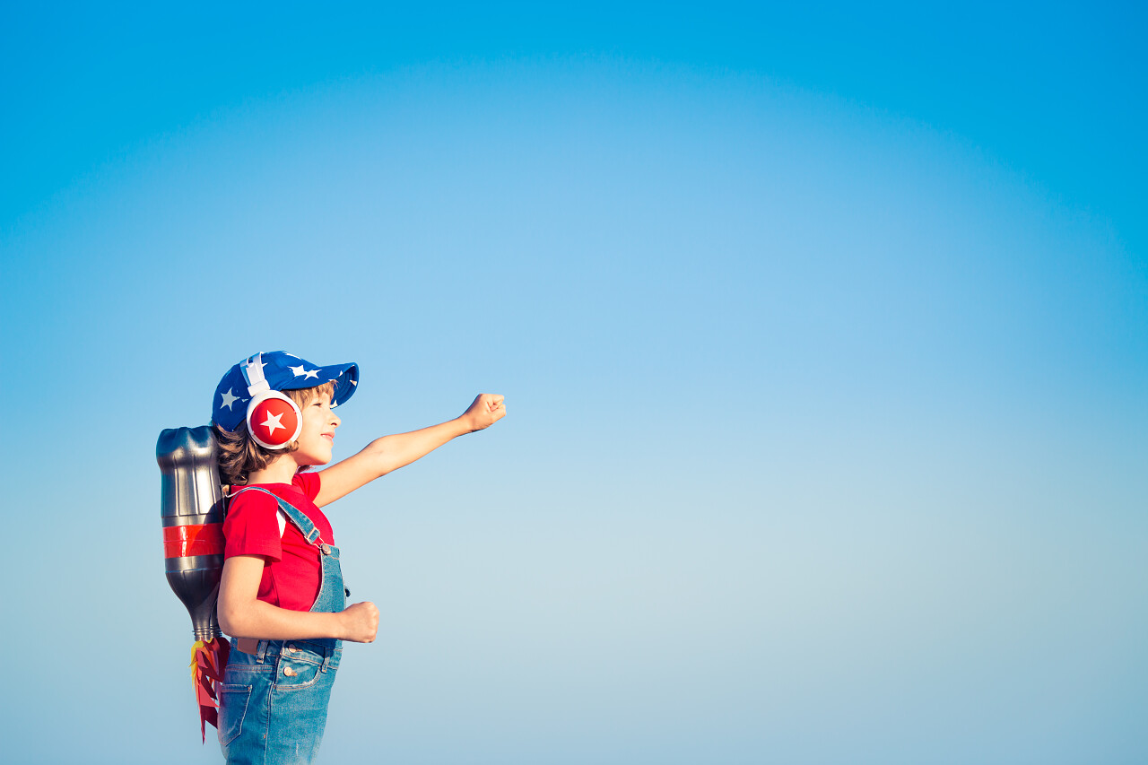 孩子用喷气式飞行背包蓝色的天空