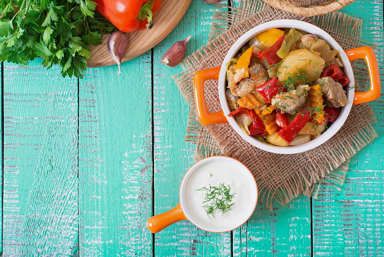 在桌子上的面包和蔬菜炖的肉