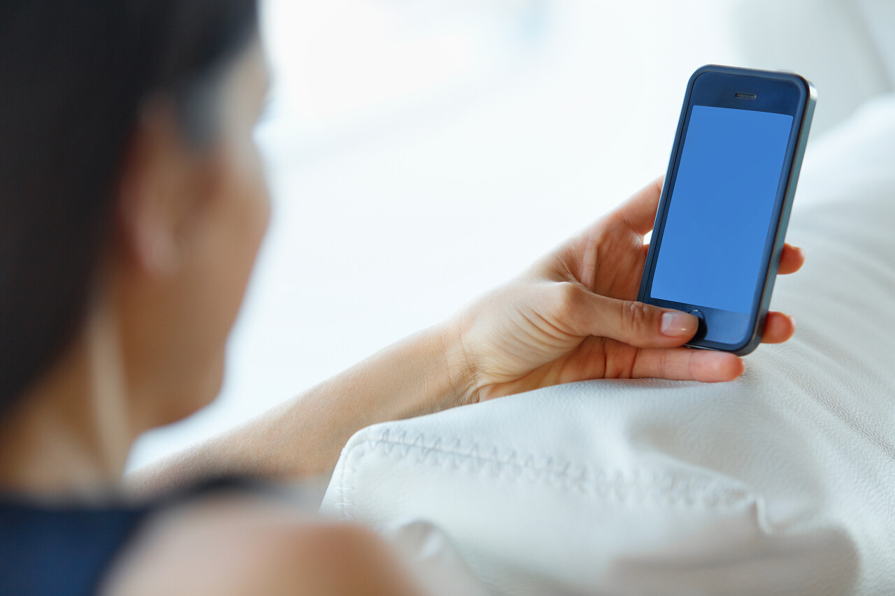 在办公室使用她的智能手机的女商人