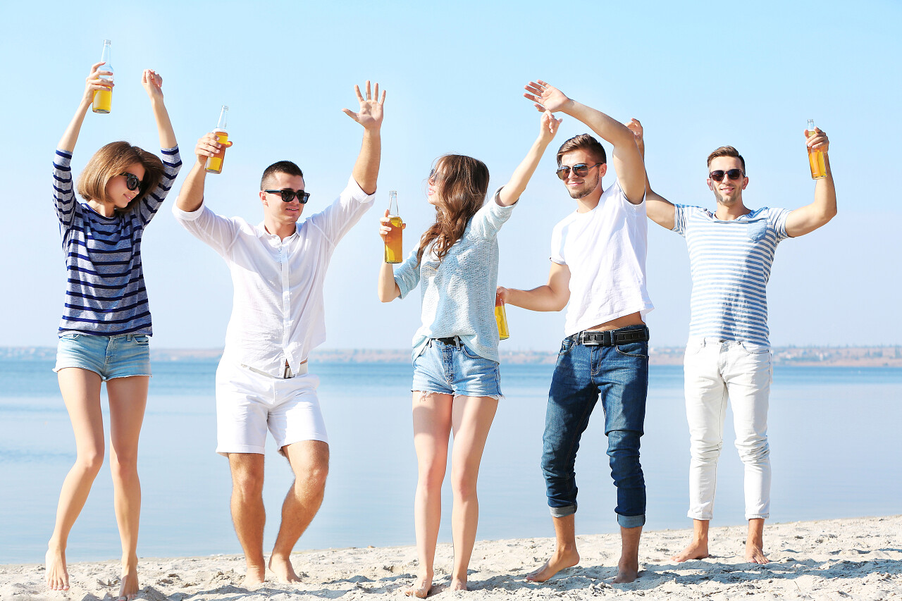 漂亮的年轻人们在海边喝啤酒青春活力