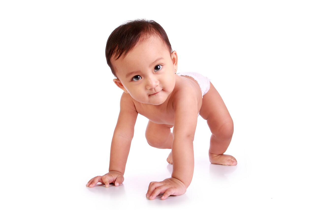 白色背景上快乐亚洲婴儿爬行和微笑