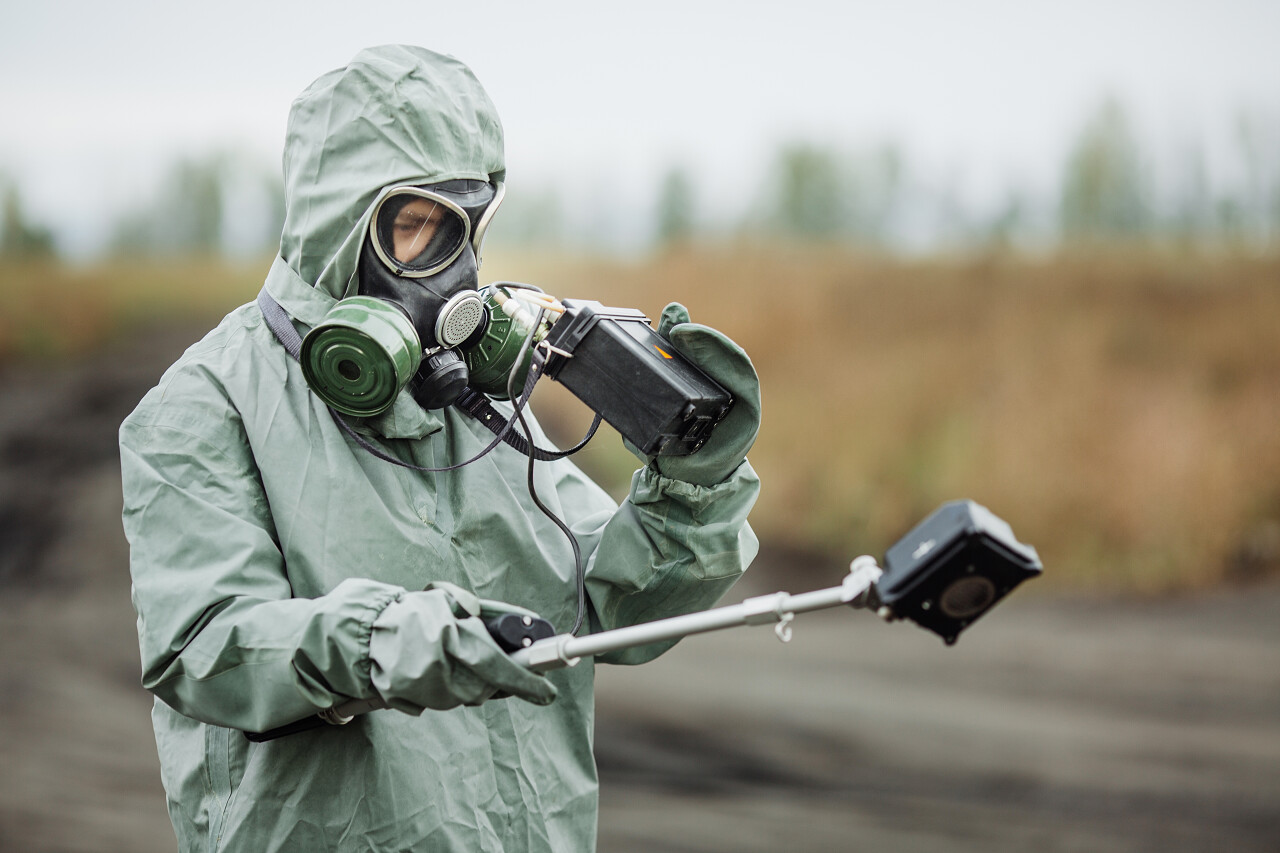 科学家穿着防护服和防毒面具在检查危险区域的辐射