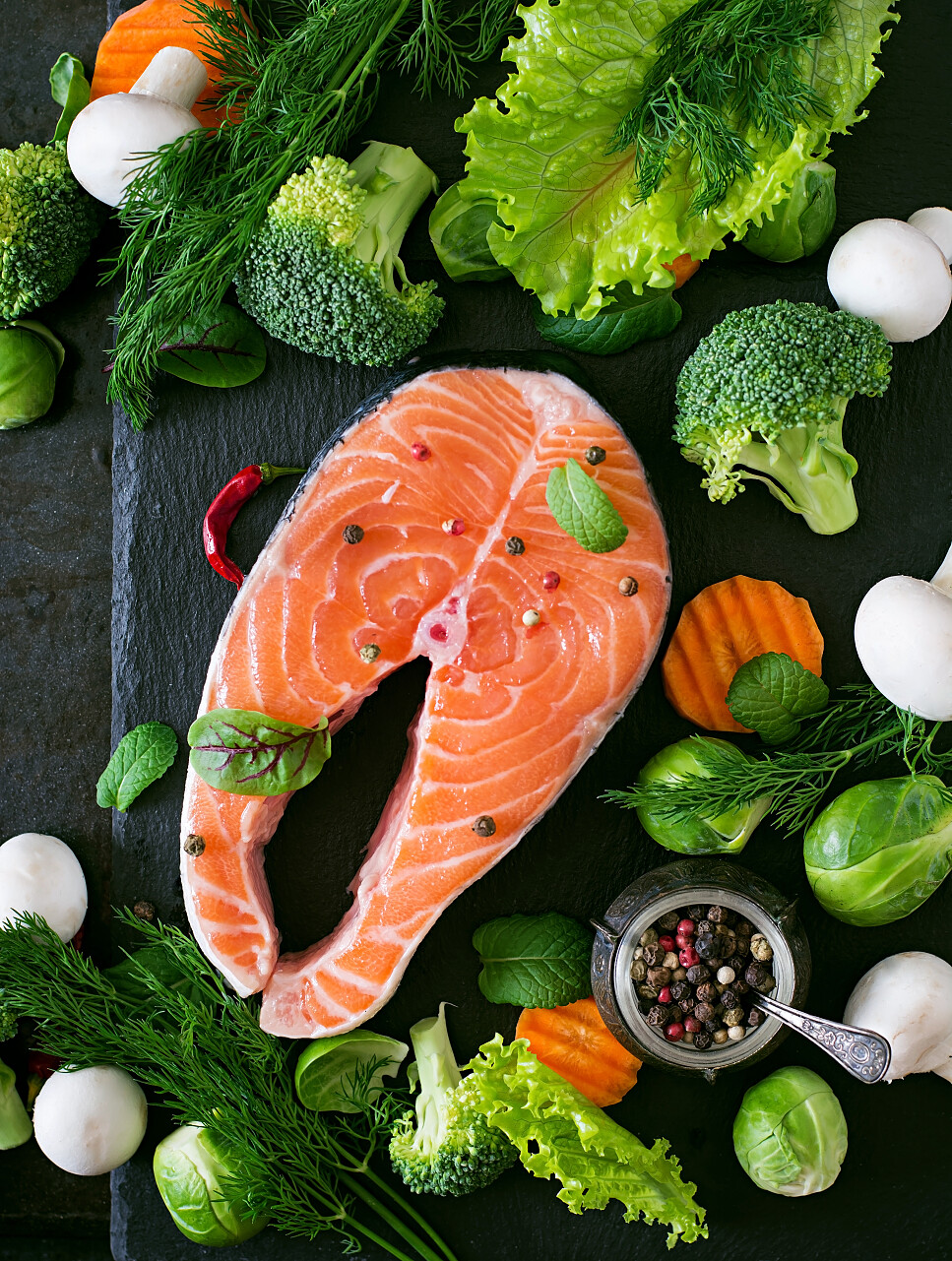 生的三文鱼排搭配上绿色健康的花菜青菜生菜组合而成的健康美食