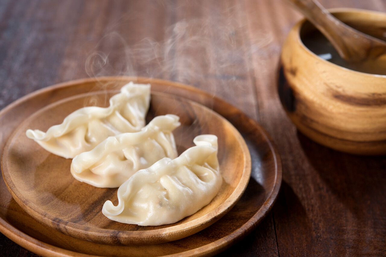 木制盘子放着传统美食饺子还冒着热气