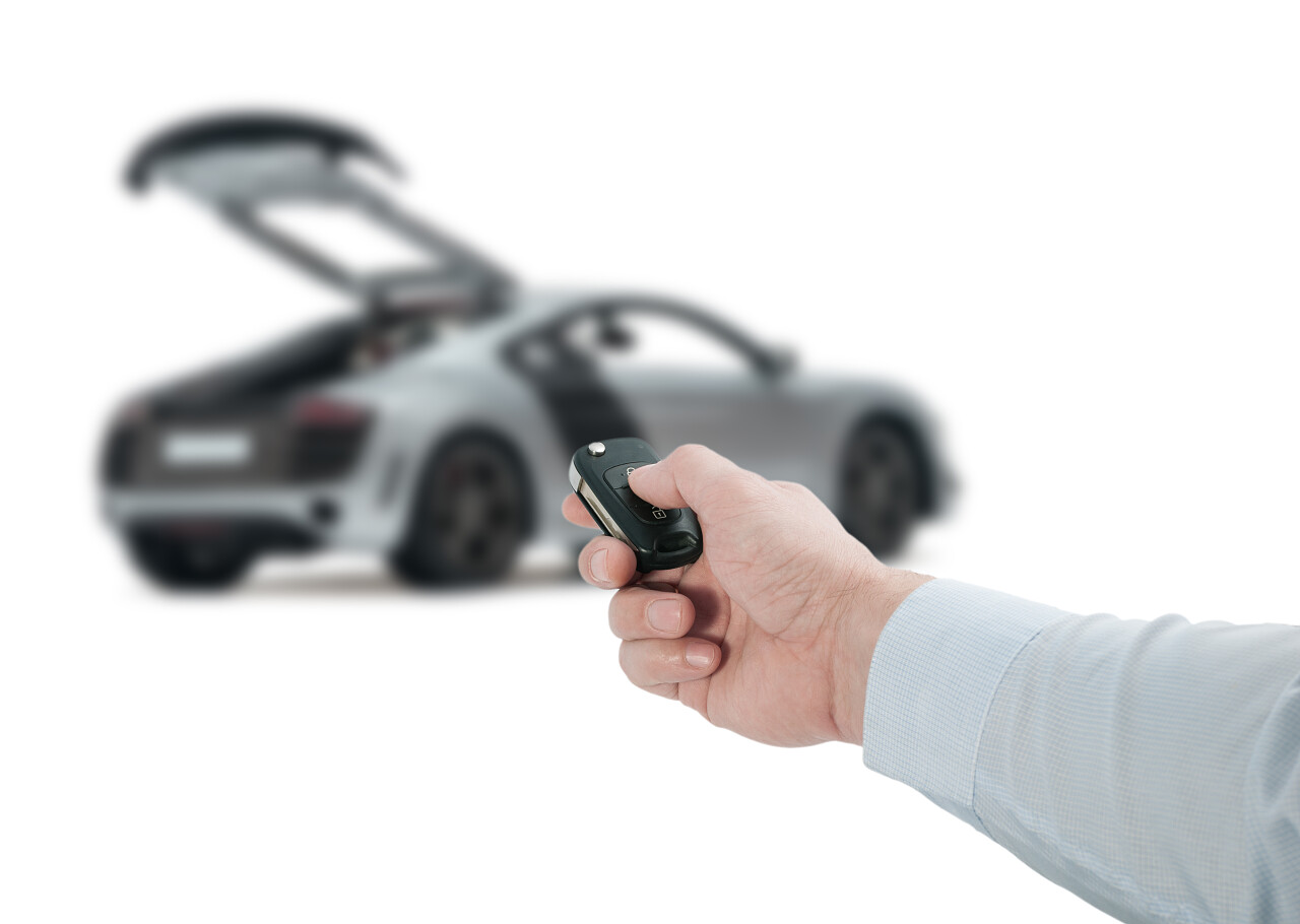 商务男士手拿着车钥匙打开面前的汽车