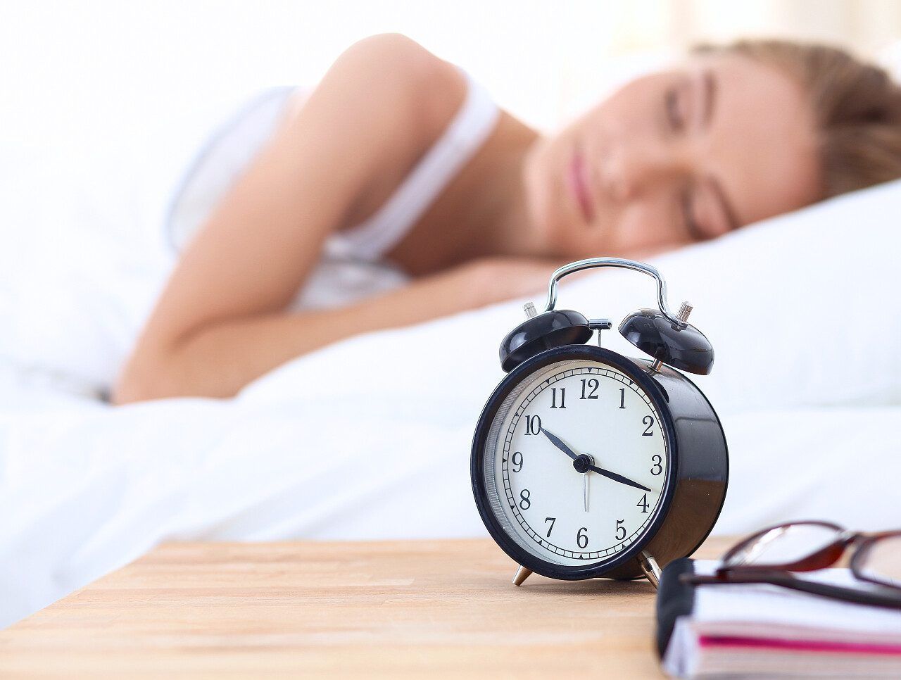 正在睡觉的年轻女子和卧室里的闹钟