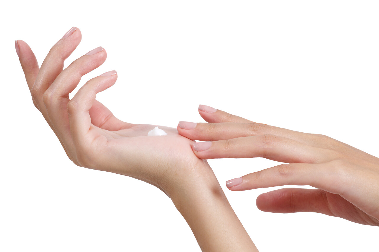 女子在手上摸着乳液和面霜