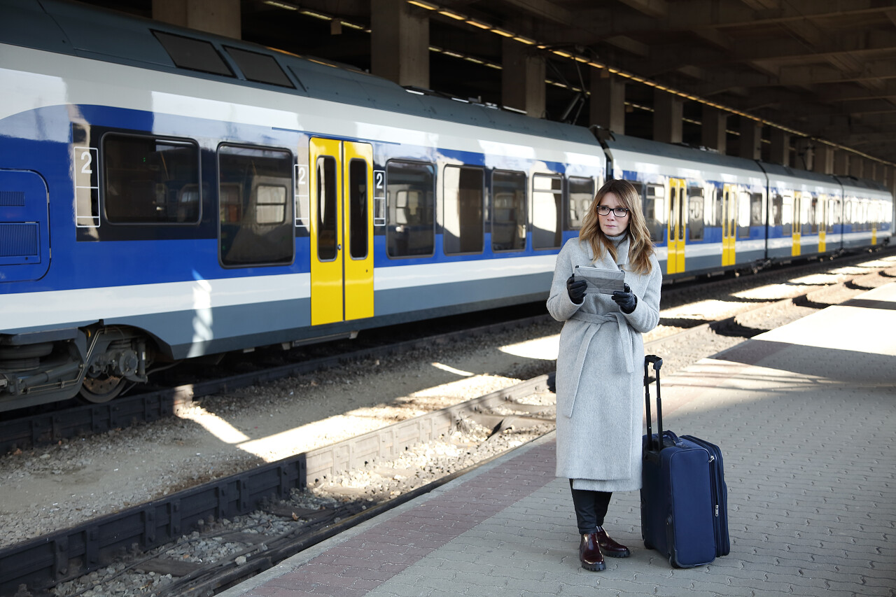 年女商人持有数字平板等待火车
