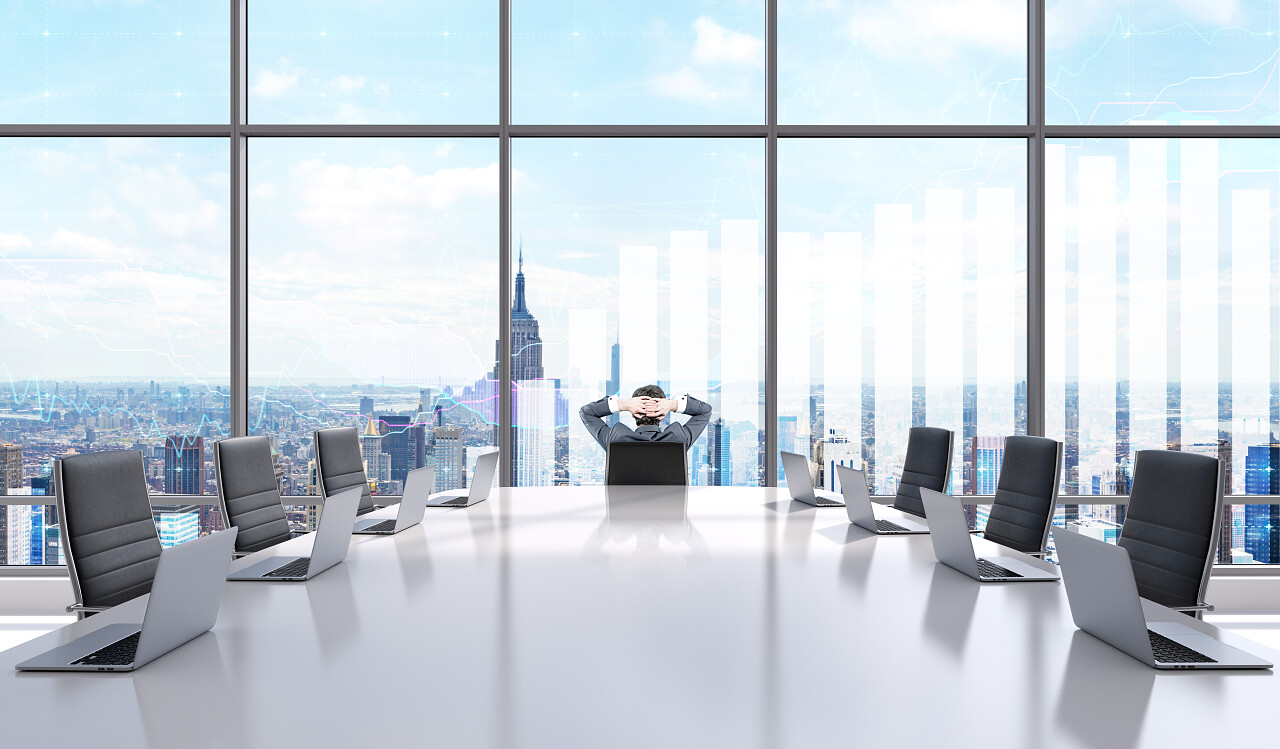 会议室一位商人双手放在头上靠在椅背上看着一个全景窗户放松