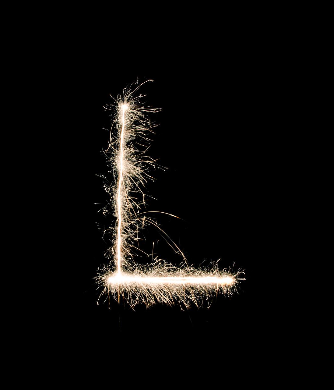 黑色背景上有个用烟花棒摆出的L形状