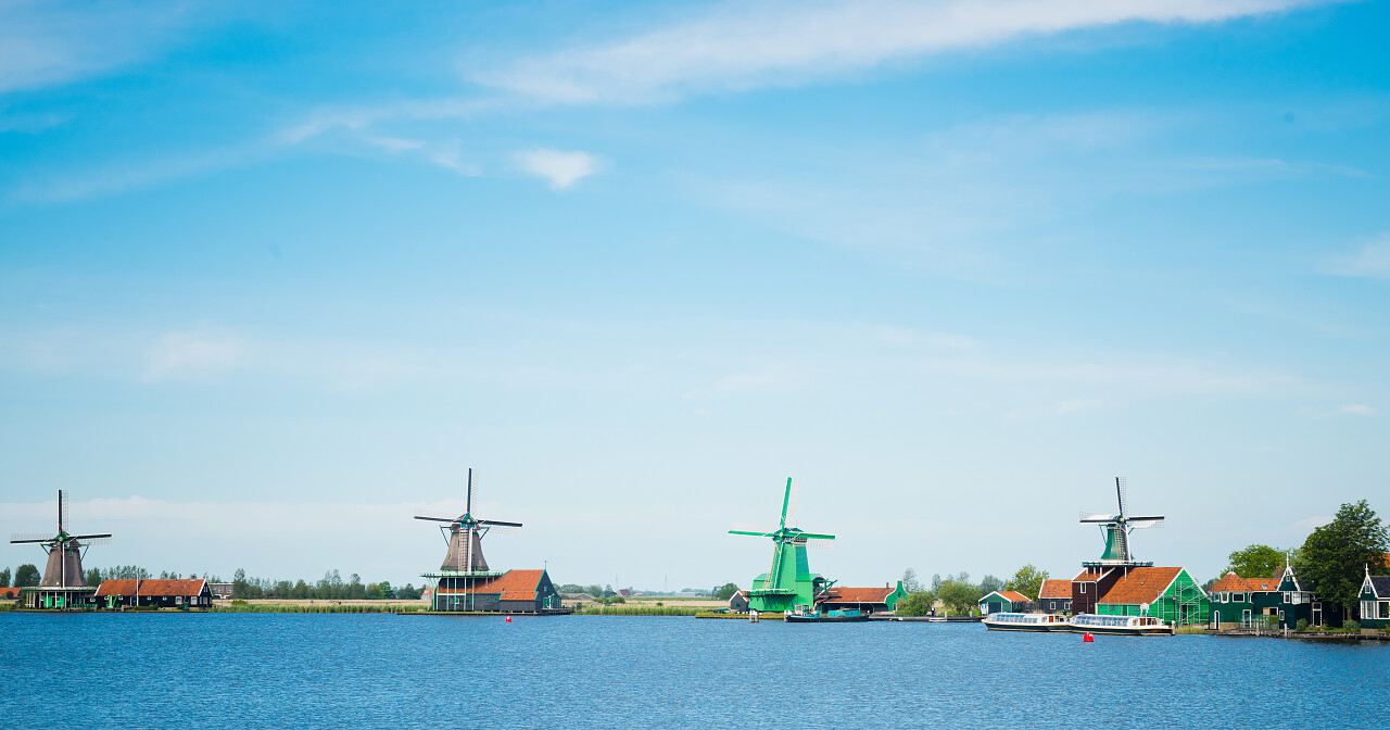 蓝色天空下随着海洋的伴舞起飞的风车