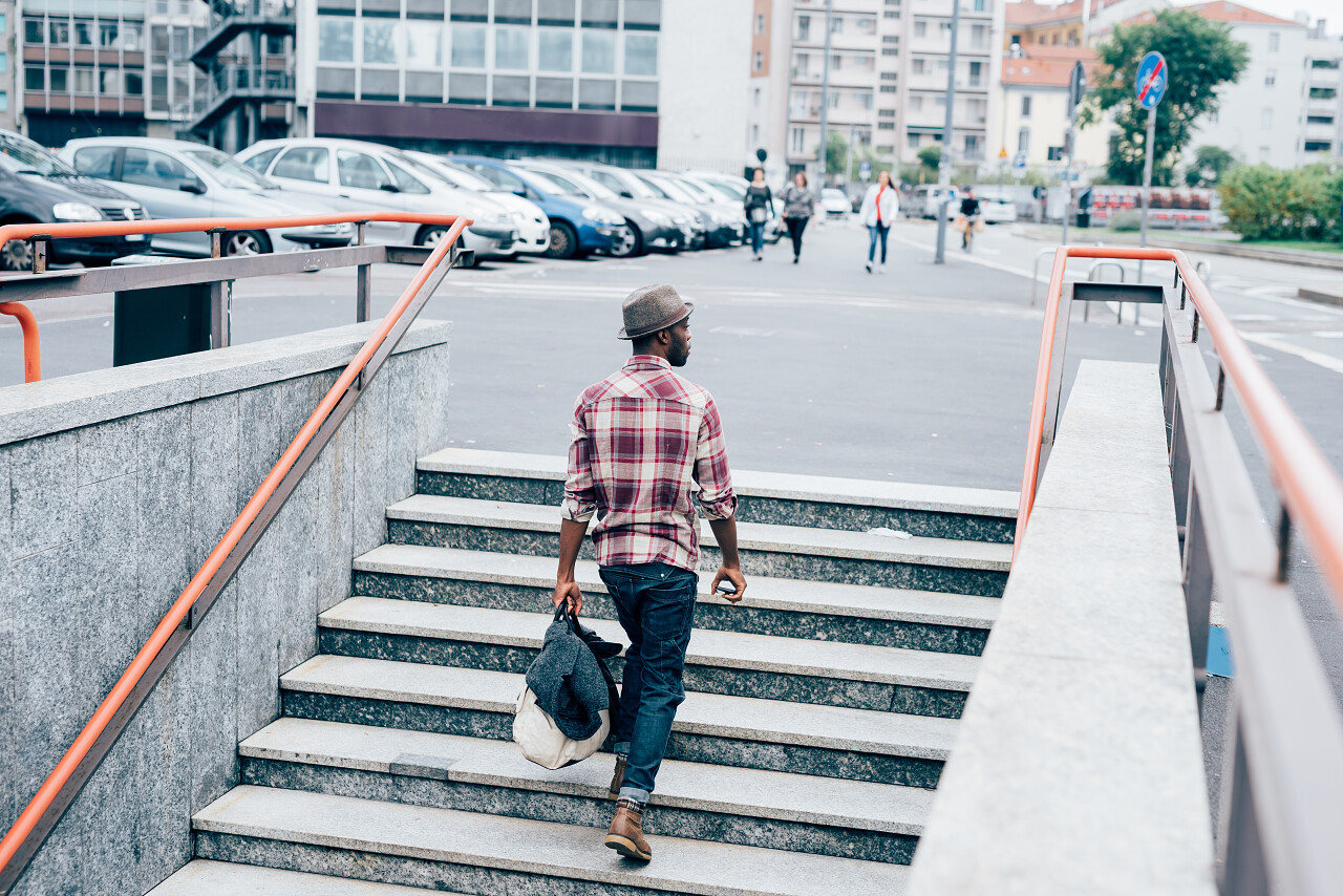 一个年轻的黑人朋友正在手拿一袋智能手机