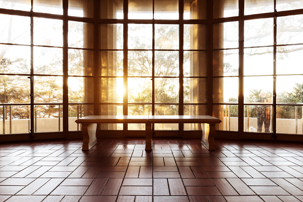 豪华大厅里折射阳光的玻璃墙砖地板上的木凳