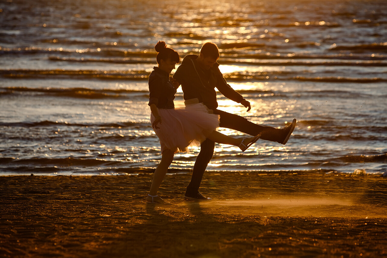 夕阳男人女人沙滩跳舞的剪影
