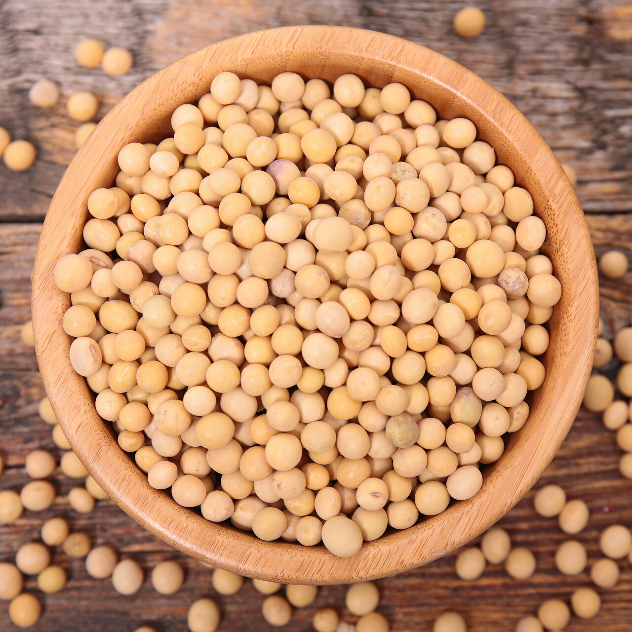 木质背景上的一碗溢出的大豆素材