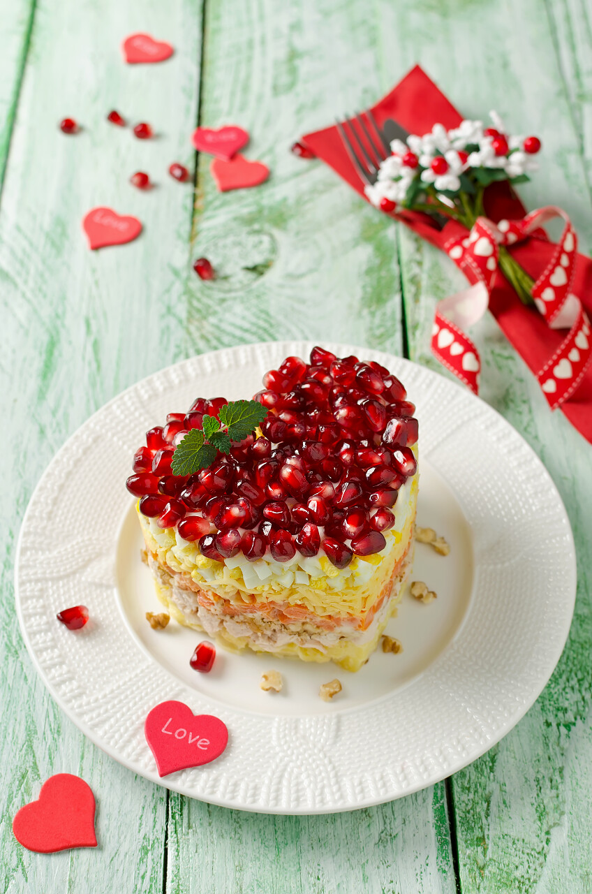 绿色木质背景下情人节餐桌上的蔬菜分层的沙拉日记情人节